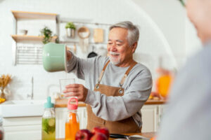 A middle-aged man pours drinks for guests at home