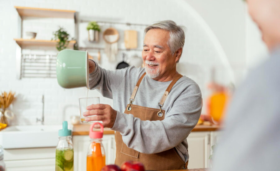 A middle-aged man pours drinks for guests at home