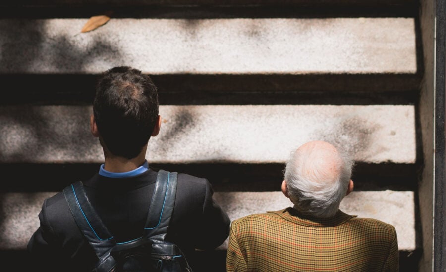 A young man and an older man walking up stairs. This symbolizes how much you need to retire by starting to invest in your 20s