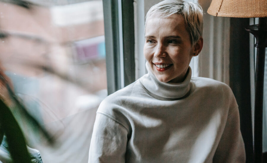 A middle aged woman sits by a window in a cafe