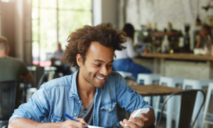 A man sits at a desk, checking his high-interest savings account balance.