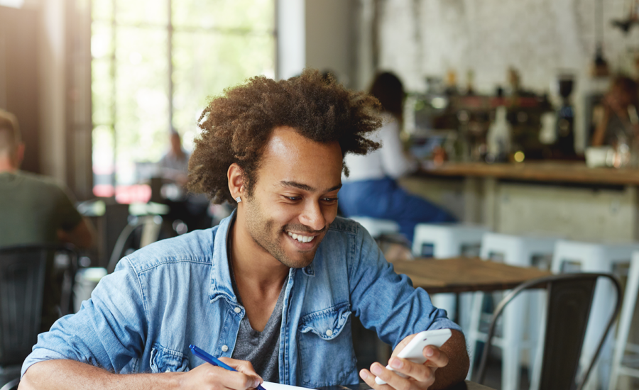 A man sits at a desk, checking his high-interest savings account balance.