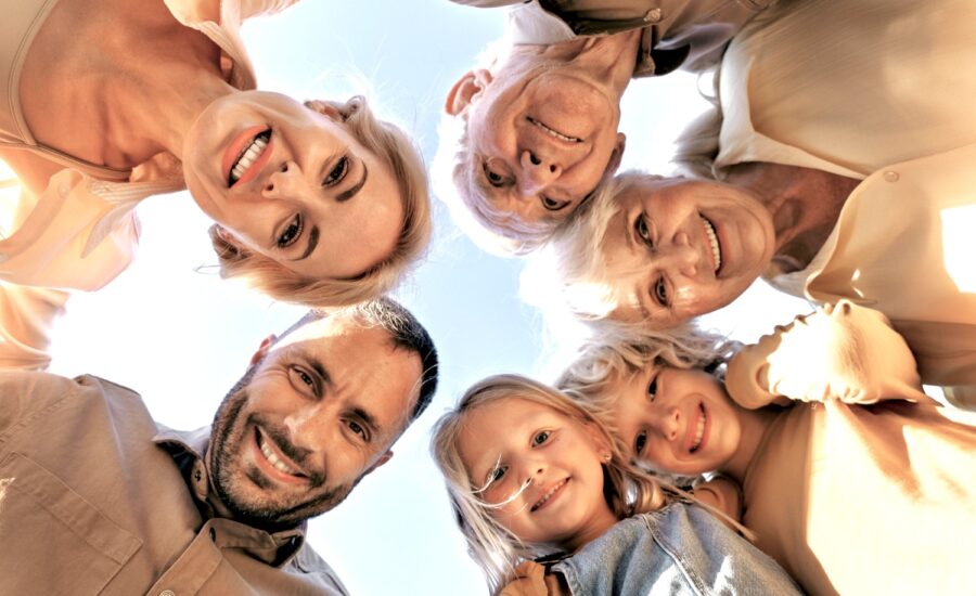 Two parents, two grandparents and two kids in a circle smile down at the camera