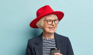 A woman in her 60s holds a coffee, pondering how to have the most tax-efficient retirement income plan