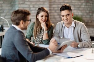 A young couple meet with a financial planner in his office