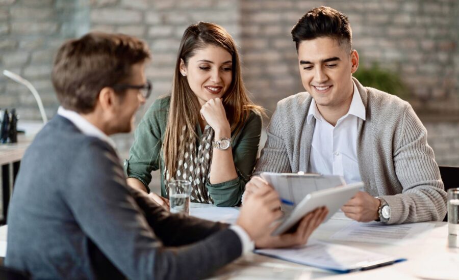 A young couple meet with a financial planner in his office