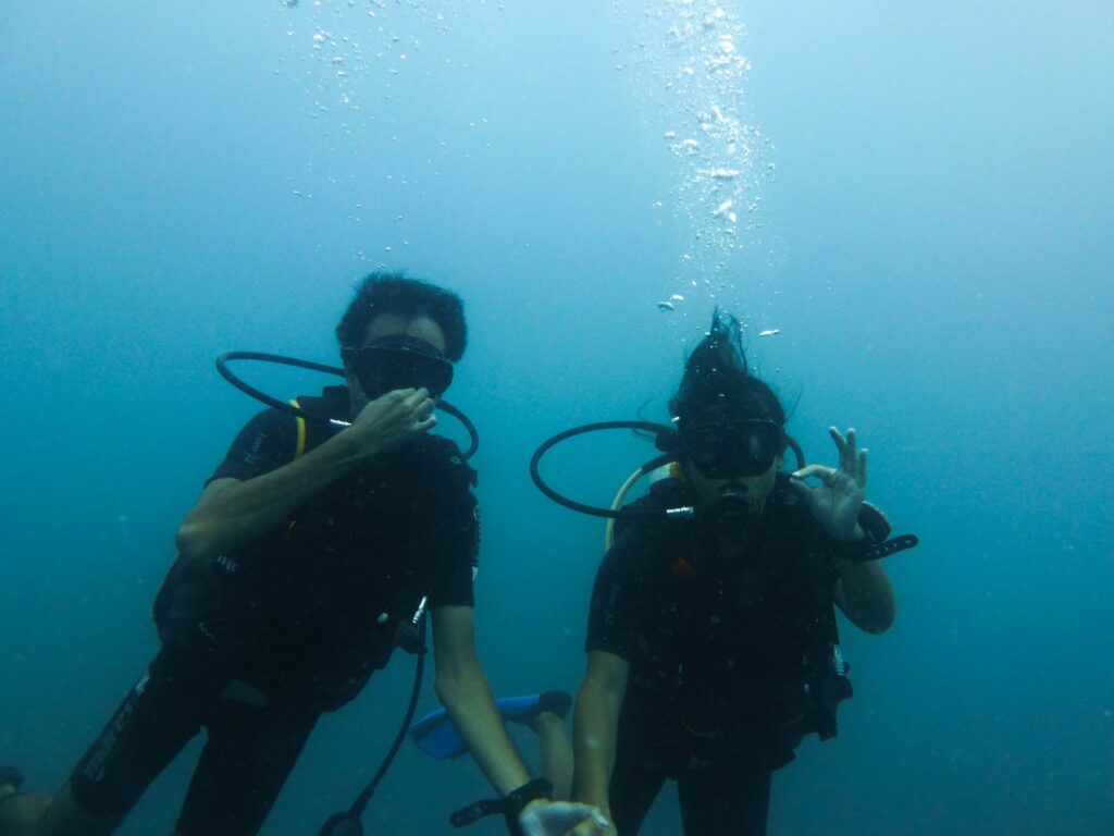 A man and a woman underwater in scuba gear
