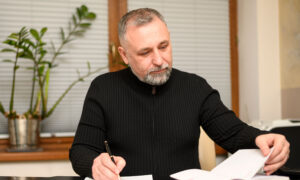 Man is reading the T5 from cashing in his whole life insurance policy, and checking his notes from when he bought it.