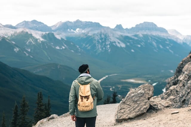 A man on a hike in the mountains enjoys the active lifestyle in Alberta.