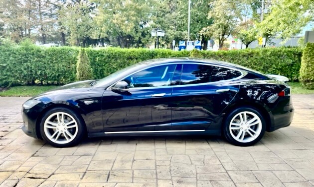 Side view of a Tesla Model S sedan on a driveway