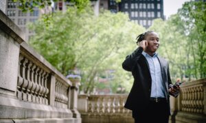 A man speaks on this cellphone in a park