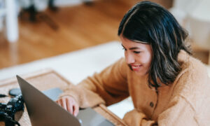 A woman reading the MoneySense list of "Best online brokers in Canada for 2023" on her laptop.