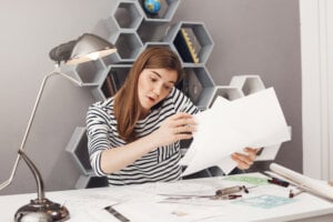 A young woman organizes papers on her desk