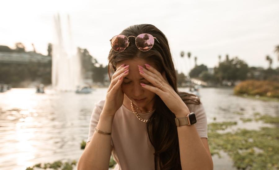 A woman facing financial decision fatigue rests her head in her hands, looking frustrated.