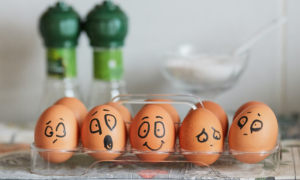 Eggs sit in a carton with different expressions drawn in black marker to represent investor behavior.