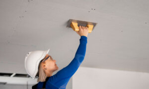 A woman repairs a ceiling, and this column talks about the U.S. debt ceiling, bank and retail earnings, optimism in investing and more.