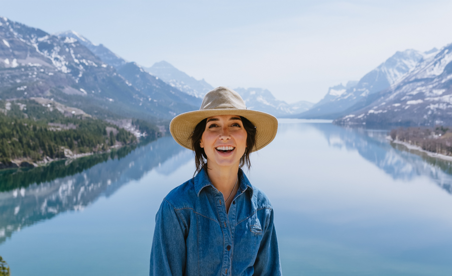 A woman who is happy about her move to Albertastands in front of the rocky mountains.
