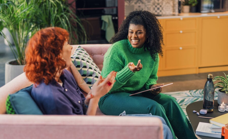 two women smiling as they discuss