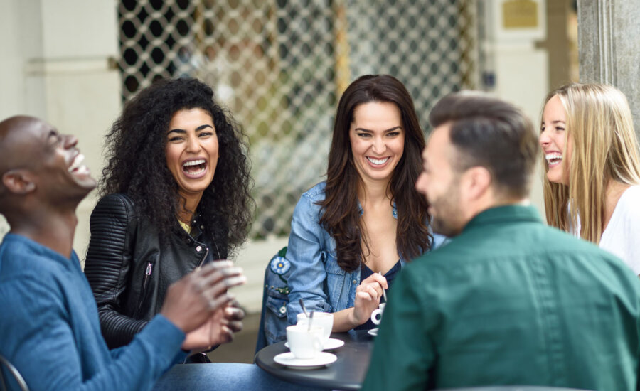 Friends together enjoying a coffee, as the topic of spending on experiences and affordability comes up