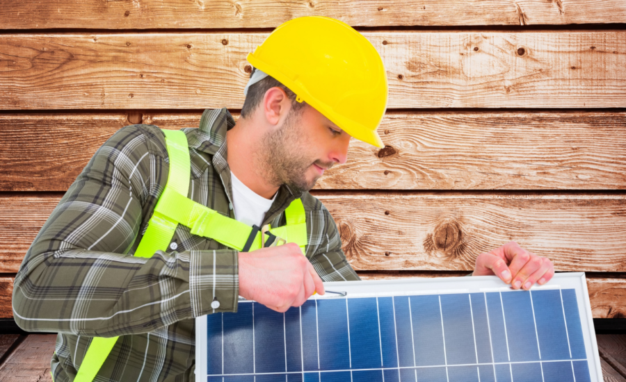 A man in a hard hat holds a solar panel