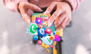 A phone bursting with tech emojis to symbolize tech taking over telecom