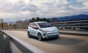 A white Chevrolet Bolt on a highway ramp