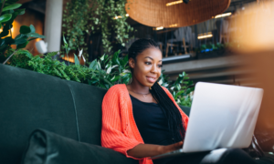 A woman readers about Fidelity ETFs on her laptop at a cafe