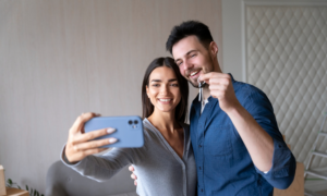 Young couple taking a selfie with house keys