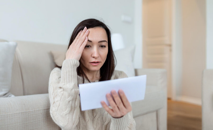 A woman is worried by a letter from her landlord.