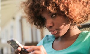 A young woman checks her child's RESP balance on her phone