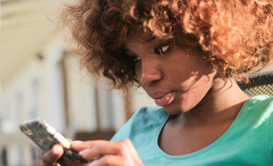 A young woman checks her child's RESP balance on her phone