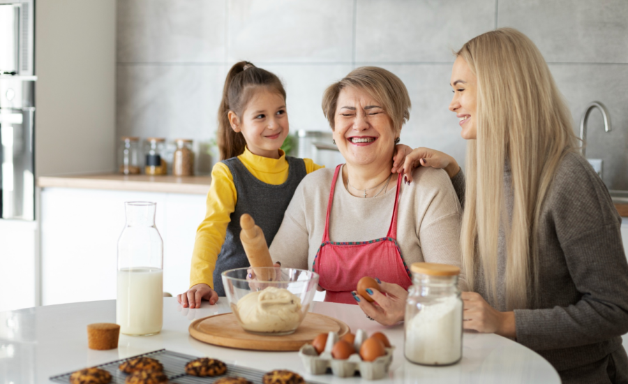 A grandmother, mother and young girl bake cookies together