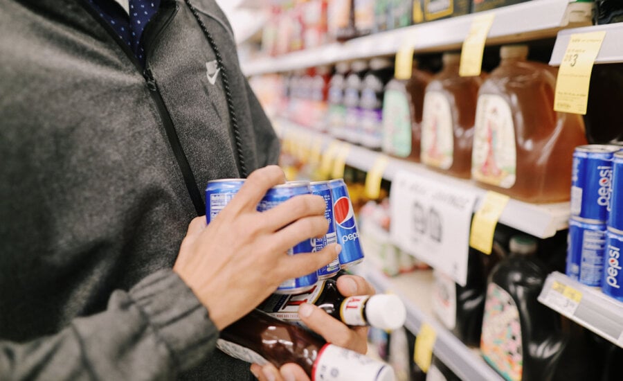 Man holding "shrinkflation" cans of Pepsi, as this column talks of inflation and Pepsi earnings