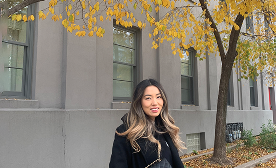 Canadian de-influencer Jennifer Wang is pictured in front of fall foliage.