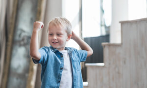 A toddler boy flexes his arm muscle