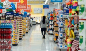 A man wanders through the aisle of a big box store talking on his cell phone