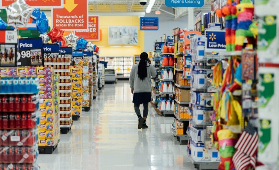 A man wanders through the aisle of a big box store talking on his cell phone