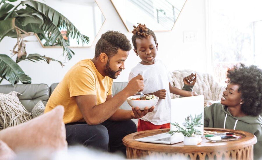 A young family discusses the rising costs of food in their living room