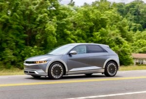 A grey Ioniq 5 drives down a street