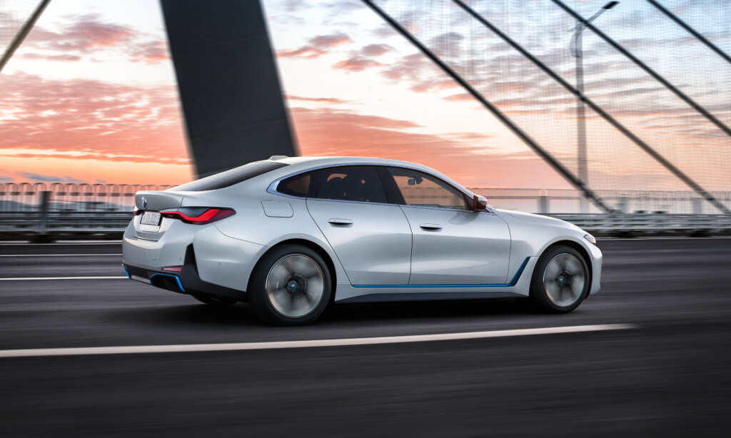 A BMW i4 sedan driving on a bridge