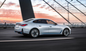 A BMW i4 sedan driving on a bridge