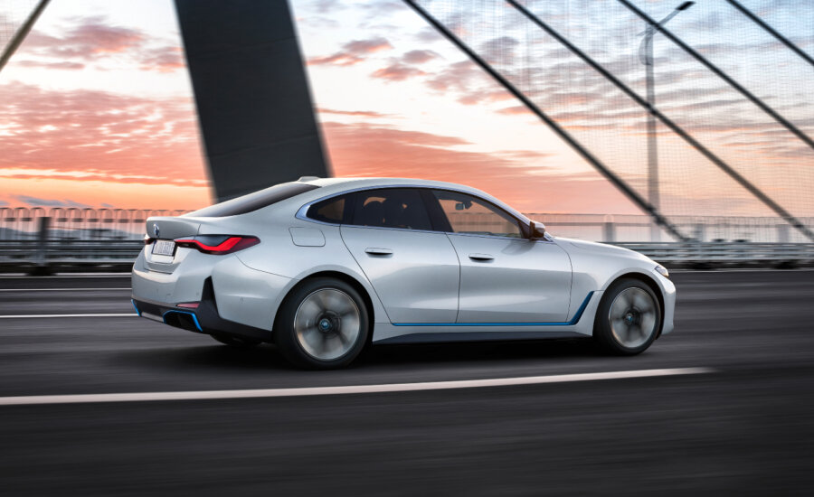 A BMW i4 sedan driving on a bridge