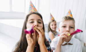 Three young kids wearing party hats