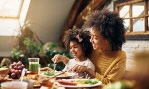 A mother and daughter enjoy lunch at home