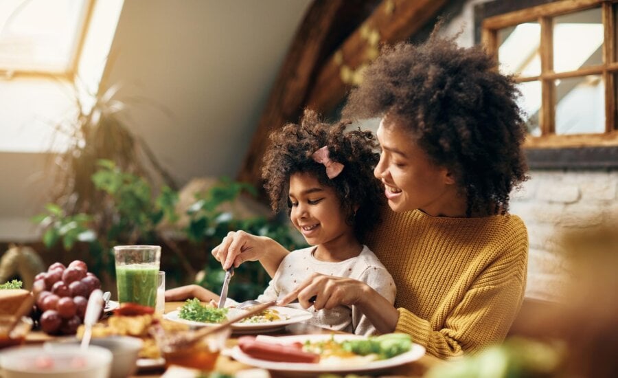 A mother and daughter enjoy lunch at home