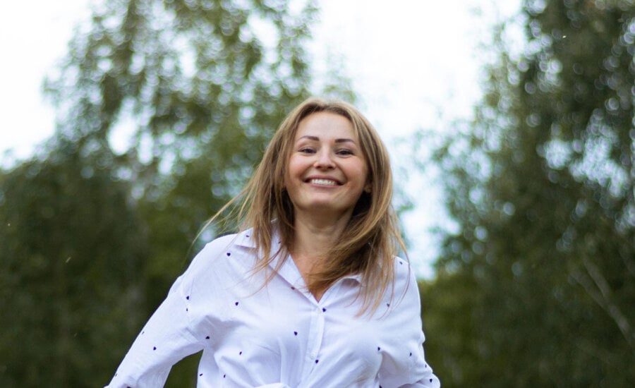 A woman smiling after learning what she should do with $100,000