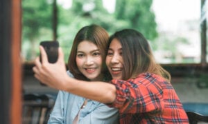 Two young women take a selfie at a restaurant