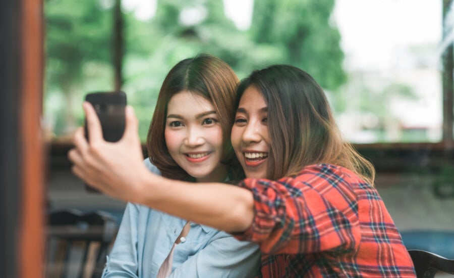 Two young women take a selfie at a restaurant