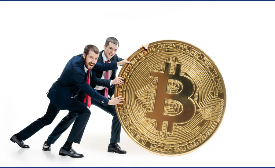 Two men pushing an oversized bitcoin.