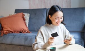 A woman uses her Visa card to make an online payment